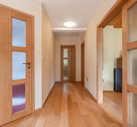 Hallway in a family house with doors and a floor with a wooden decor.