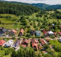 Family houses in Horná Lehota surrounded by green hills and dense forests.