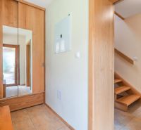 A hallway in a family house with wooden decor and a wardrobe.