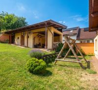 A family house in Horná Lehota with a wooden shelter and a large grassy yard.
