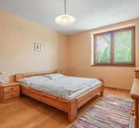 A bedroom with wooden furniture and a wooden decor floor in a family house.