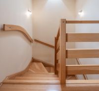 A staircase with a wooden railing and a floor with a wooden decor in a family house.