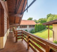 A family house in Horná Lehota with a wooden balcony and a garden with trees.