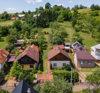 Family houses in Horná Lehota surrounded by greenery and hilly terrain.