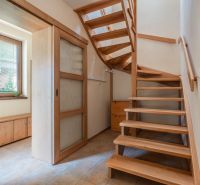Interior of a family house with a wooden staircase and sliding doors.