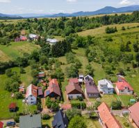A view of family houses in Horná Lehota with hilly landscape in the background.