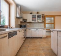 Kitchen in a family house with wooden decor, equipped with furniture and appliances.