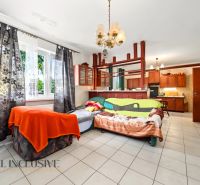 Living room with a large window, a pull-out sofa, and a kitchenette in a family house.