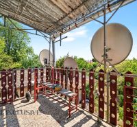A balcony of a family house in Bodza with satellites and greenery in the background.