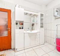 A bathroom in a family house with white furniture and a washing machine.
