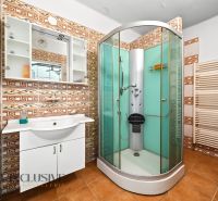 Bathroom in a family house with a shower and ceramic tiles.