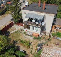 A family house in Bodza with two chimneys, a terrace, and a spacious garden with trees.