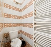 A bathroom with tiles in a family house, white heating, patterned tiles.