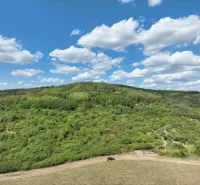 Agricultural and forest lands in Tornaľa with beautiful green hills and blue skies.
