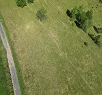 Aerial photograph of the landscape near Stará Ľubovňa, highlighting green meadows and tree scenery.