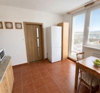 Kitchen in a 3-room apartment with a dining table and a view of the exterior.