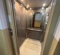 Renovated elevator with wood decor on the walls in a 3-room apartment.