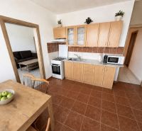 A kitchen in a 3-room apartment with wooden decor and a dining table.