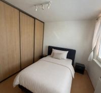A bedroom in a 3-room apartment with a bed, built-in wardrobe, and a window.