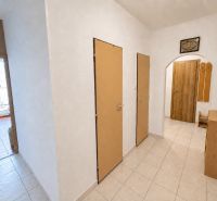 A hallway in a 3-room apartment with tiles and simple furniture.
