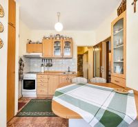 A kitchen unit in a one-room apartment with wooden accessories and appliances.