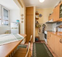 A kitchen in a studio apartment with a wood decor and white appliances.