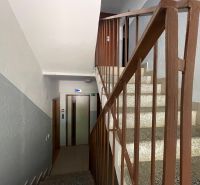 A staircase with a metal railing and access to the elevator on Hany Meličkovej in Bratislava.