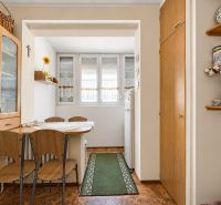 Dining area with wooden chairs and table, floor with wooden decor.