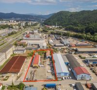 A building in the industrial zone on Zvolenská Street in Banská Bystrica surrounded by nature and buildings.