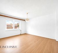 A family house with a wooden decor floor and a chandelier, white walls, large window.