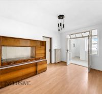 A room in a family house with a wooden decor floor and older furniture.