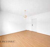 White room in a family house with a wooden decor floor and a chandelier.