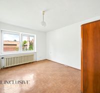 Empty room with a window, wood-patterned floor, and a cabinet in a family house.