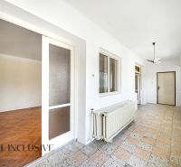 A hallway with a covered floor, a large window, and a door in a family house.