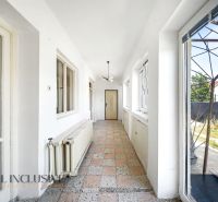 A bright hallway with windows and tiles in a family house.