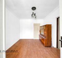 A room with a wooden decor floor and a wooden wardrobe in a family house.
