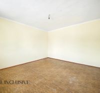 An empty room with wood-patterned flooring and cream walls in a family house.