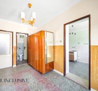 A hallway in a family house with wooden decor and a bathroom.