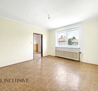 A spacious room with a wooden decor floor and a large window in a family house.