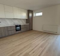 A kitchen in a 3-room apartment with a wooden decor floor and a balcony.