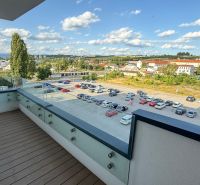 A balcony with a wooden decor floor offers a view of Zvolen, Kubániho Street.