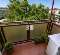 The balcony of a 2-room apartment in Nitra with a view of a greenery-surrounded housing estate.