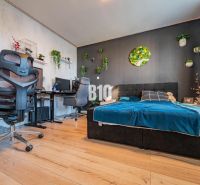 Bedroom of a 3-room apartment with stylish decoration and wooden decor flooring.