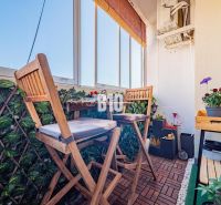 Glazed balcony terrace with wood-decor flooring and plants in a 3-room apartment.