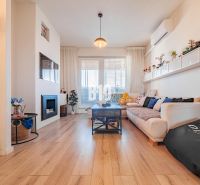 Living room in a 3-room apartment with a wooden decor floor, sofa, and fireplace.