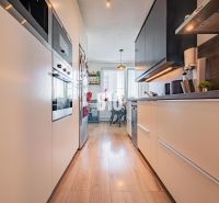 A kitchen in a 3-room apartment with a wooden decor floor and appliances.