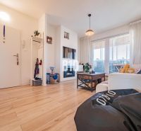 Living room in a 3-room apartment with a wooden decor floor and comfortable seating.