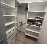 Storage space with shelves, drawers, and a wooden decor floor in a 2-room apartment.