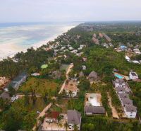 A view of the coastline and family homes in Fumba Town, surrounded by tropical nature.