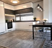 Kitchen and dining area in a family house with a wooden decor floor.